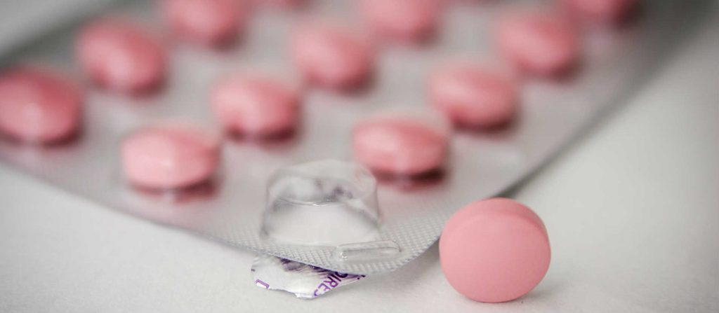 A pink antihistamine tablet out of the packet
