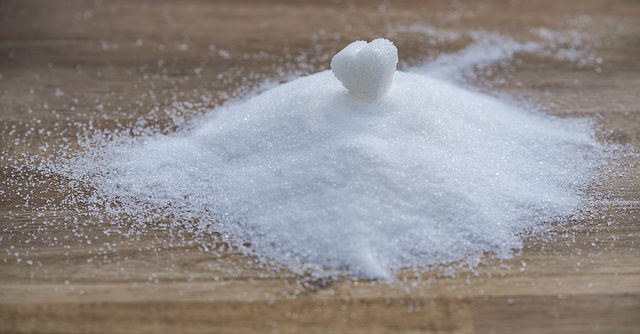 A pile of white granulated sugar on wood