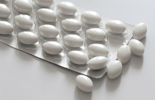 A packet of white oval medication tablets