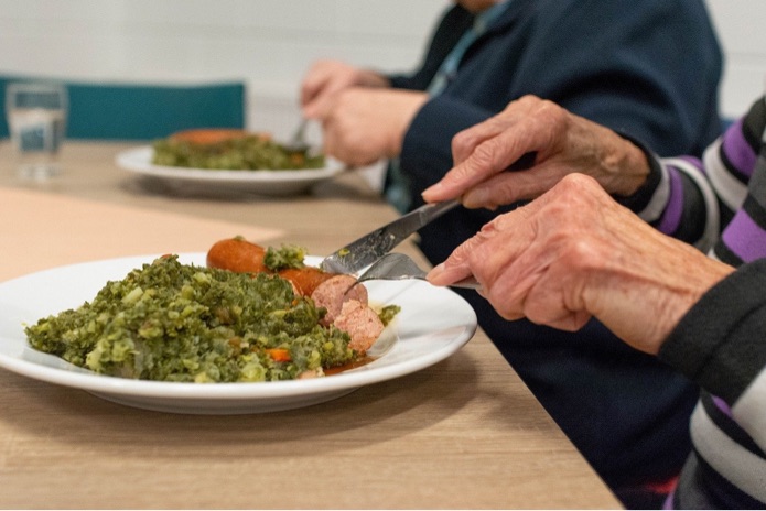 An older person is eating a meal